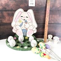 Two large inflatable Easter bunnies, one pink and one purple, each holding a carrot.