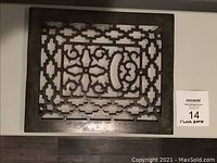 Top down view of the antique cast iron floor grate showing detailed ornate pattern and size relative to surface below.