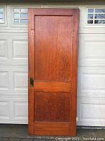 Full front view of antique wooden door showing two panels and finish condition