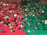 Wide view of assorted pins spread out on a puzzle-mat including geographic and sports pins