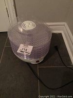 Salton multi-tray food dehydrator assembled, showing white base unit with power cord and stacked transparent trays topped with clear vented lid.