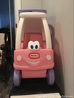 Front view of Little Tikes ride-on car cart with smiling face design in pink and purple colors.