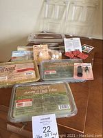 Photo showing soap base tubs labeled 'Olive Oil Soap Suspension Formula,' assorted soap making supplies, molds, scent bags, and soapmaking book.