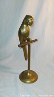 Front angle view of the brass parrot on stand showing the full figure and base.