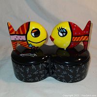 Front view of the porcelain jewelry box showing colorful fish pop art figures and signature on the base.