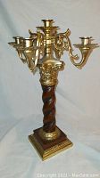 Full view of five candle brass and wood candelabra showing the spiral wood pillar and brass arms with candle holders