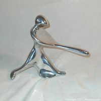 Side angle of chrome baseball batter figurine showing polished finish and abstract form