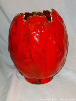 Red egg-shaped mid-century modern lava glaze vase with a cracked organic opening at top shown from front angle.