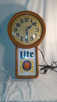 Full front view of the vintage Miller Lite beer clock showing the clock face and illuminated advertising panel below.