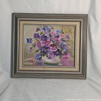 Framed oil painting on board showing pansies in a white vase with signature R. Haddock in lower left corner