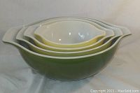 Four graduated vintage Pyrex mixing bowls stacked nested inside each other.