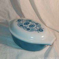 Vintage Pyrex 1.5 quart casserole dish with lid, blue base and white lid with blue floral pattern.