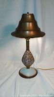 Front view of the vintage pottery lamp with copper shade showing the textured pottery base and the copper shade with layered design.