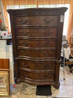 Front view of the 6-drawer dresser showing the wood grain veneer, ornate handles, and carved detail on top edge and sides.