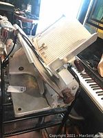 Side view of entire meat slicer showing adjustable carriage and blade