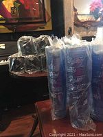 Several sleeves of blue plastic Pepsi-Cola cups, each sleeve wrapped in plastic and containing six cups.