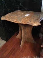 Single side table showing scalloped top and curved pedestal base