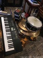 Photo of Casio CTK-2400 keyboard with cymbals and snare drum nearby