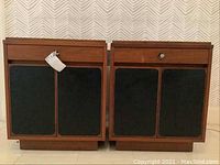 Front view of both nightstands showing walnut veneer finish and black Formica door fronts