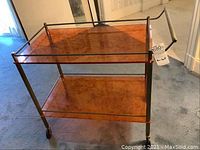 Full frontal view of two-tier bar cart showing shelves, frame, handle and wheels