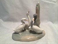 Front view of the white geese figurine with naturalistic base and cattail.