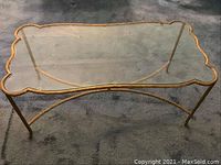Front perspective view of entire table showing gold ormolu frame with clear glass top