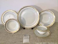 Group shot of plates, bowls, teacup and saucer displaying various pieces.