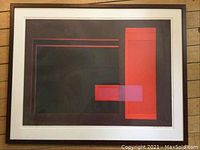 Framed collograph artwork with mainly dark colors and red rectangular shapes on it, showing overall condition and framing.