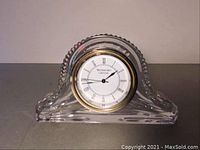 Close-up of Waterford crystal desk clock showing clear cut crystal body and gold-tone rimmed clock face.