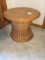 Full side view of the brown wicker occasional table showing hourglass woven design and solid construction.