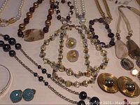 Close up showing variety of necklaces and earrings with beads and large decorative elements