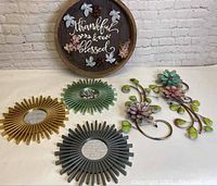 Overview of all items showing metal flower sculptures, wooden wall art, and three sunburst mirrors.