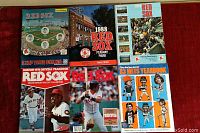 Collection of assorted yearbooks and programs for Boston Red Sox and New York Mets from 1970s and 1980s, showing covers with player photos, Fenway Park images, and colorful designs.