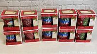 Front view of 10 boxed holiday coffee mugs in two rows showing various festive designs.