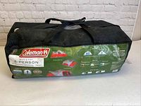 Front of the black carry bag shows Coleman branding and tent model information.