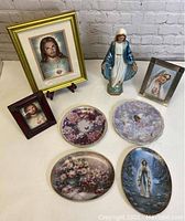 Full view of all religious themed items including framed prints, statue and decorative plates