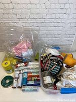 Overview photo of the lot showing multiple bags and boxes containing rolls of tulle, ribbons, and other crafting materials.