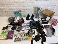 Photo showing assortment of items including hair dryers, dream catcher, storage bin, socks, books, and other small personal items.
