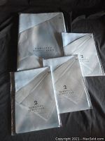 Packaged tablecloth and napkins labeled Damasten Tafellaken and Servetten showing sizes and material blend of cotton and polyester.