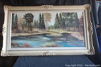 Full view of large landscape oil painting in ornate shabby chic style frame.