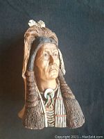 Front view of the Native Indian figurine with detailed traditional attire and feathers in the hair.