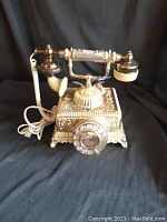 Side view of the baroque style telephone showing ornate design and handset attachment