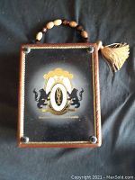 Front view of the cigar box purse showing Onyx branding and beaded handle with tassel.