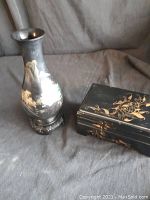 Photo showing the black lacquered 9-inch vase with gold and green floral design alongside the closed 7-inch lacquer box with gold floral pattern.