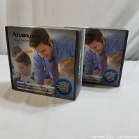 Two Alvoxcon branded boxes with wireless headset and lapel microphone visible on front showing recommended uses for presentations, plays, weddings, trainings, church.