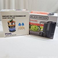 Boxes of Black+Decker Fresh Prep One-Touch Chopper and Instant Pot Accessories Set, both new in box.