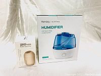 Boxed Homasy humidifier and small boxed bottle humidifier placed side by side