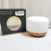 Photo of wake-up light alarm clock next to its box showing the product image and model text