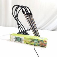 Photo of black grow light with four flexible arms that hold LED light strips attached to clamp base next to boxed 3 in 1 soil tester.