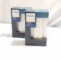 Two new sealed Philips Hue Dimmer Switches in retail boxes, showing front with branding and button layout.